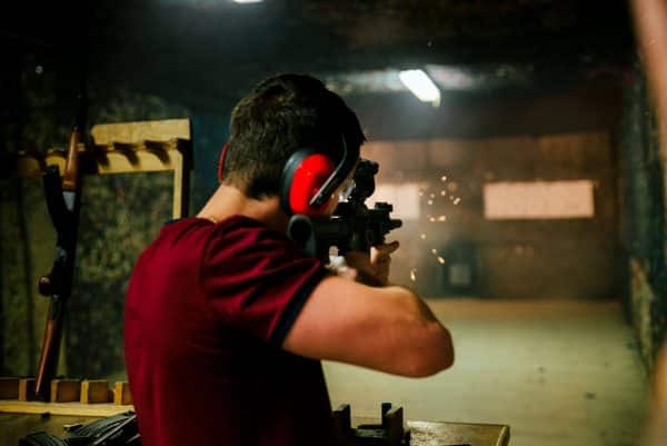 Shooting a pistol at target in indoor firing range